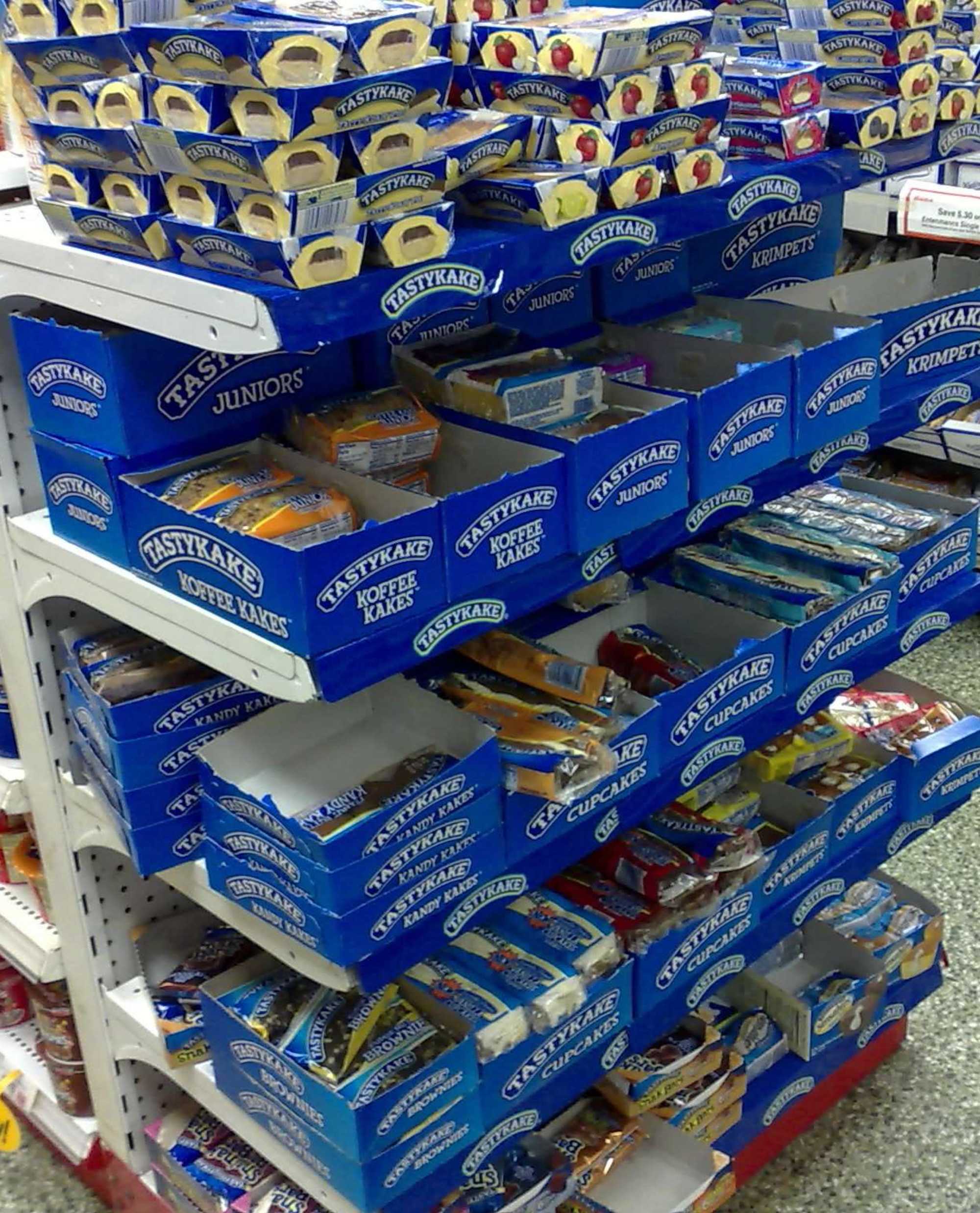 Blue boxes of Tastykake brand baked goods on store shelves.